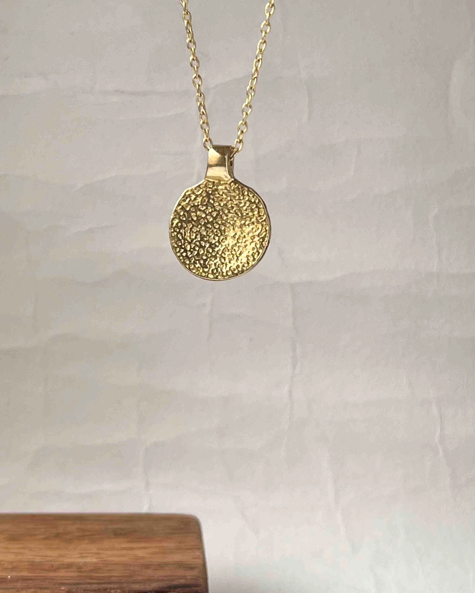 Brass necklace with a hammer texture coin pendant handmade by A Creator's Studio