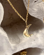 Brass necklace with a swinging and engraved crescent moon pendant handmade by A Creator's Studio