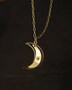 Brass necklace with a swinging and engraved crescent moon pendant handmade by A Creator's Studio