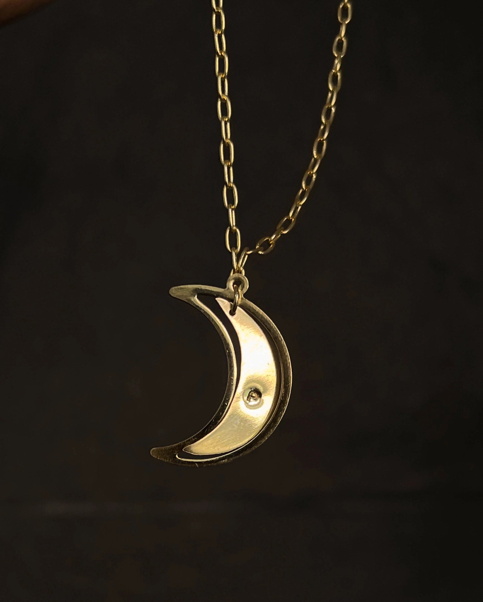 Brass necklace with a swinging and engraved crescent moon pendant handmade by A Creator's Studio