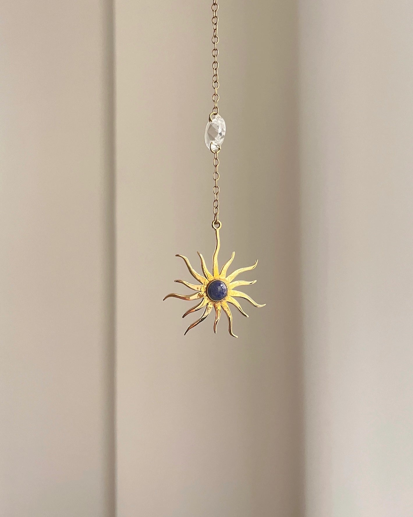 Brass sun-shaped car charm with a central gemstone handmade by A Creator's Studio