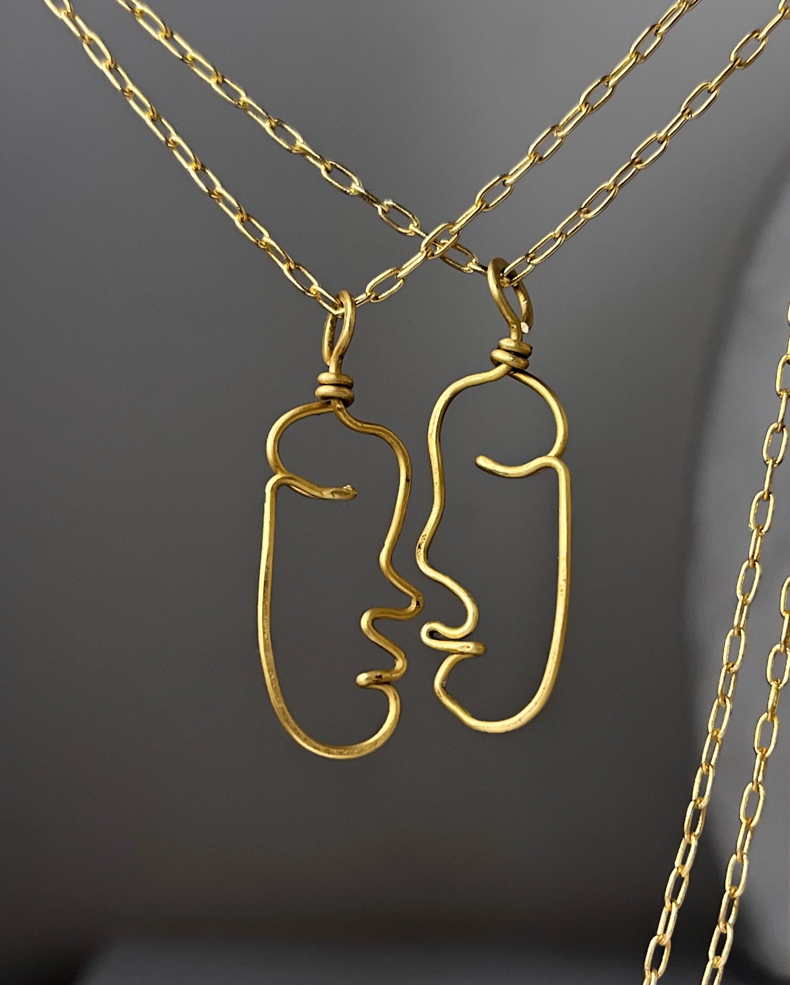 a set of two Brass wired face necklaces with chain handmade by A Creator's Studio