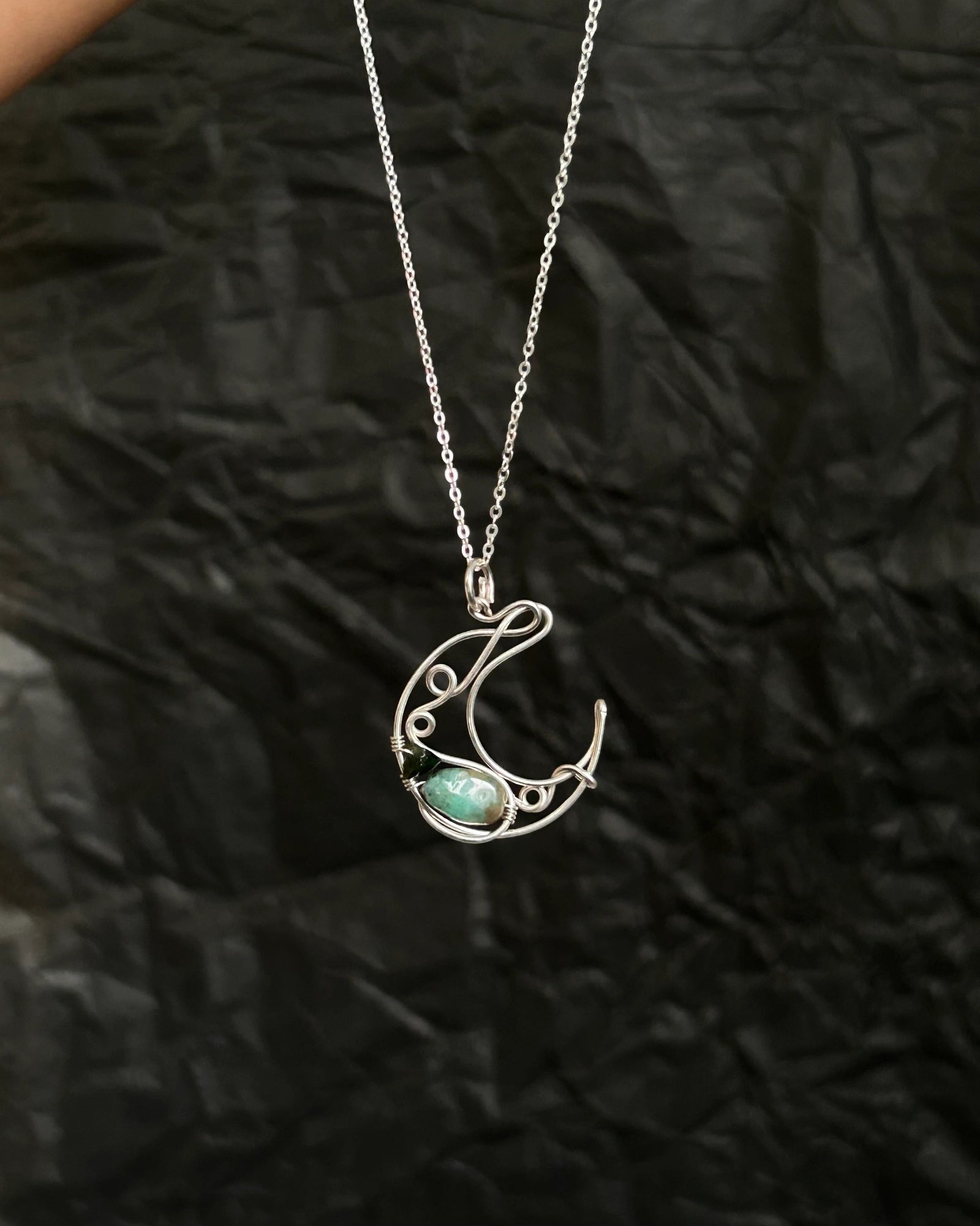 Sterling Silver Necklace with a wire wrapped moon pendant and an emerald gemstone handmade by A Creator's Studio