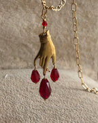Brass necklace with a hand pendant and red crystal drops handmade by A Creator's Studio