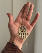 Brass hamsa-shaped car charm with a central gemstone handmade by A Creator's Studio