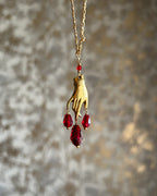 Brass necklace with a hand pendant and red crystal drops and matching earrings handmade by A Creator's Studio