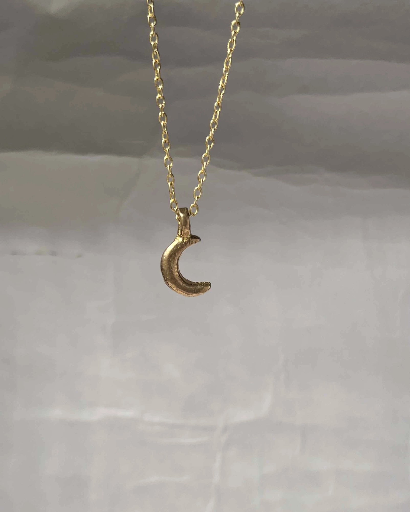 Brass necklace with a crescent moon pendant handmade by A Creator's Studio
