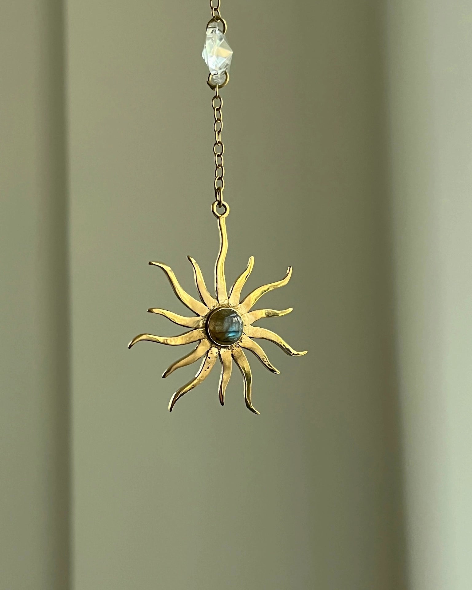 Brass sun-shaped car charm with a central gemstone handmade by A Creator's Studio