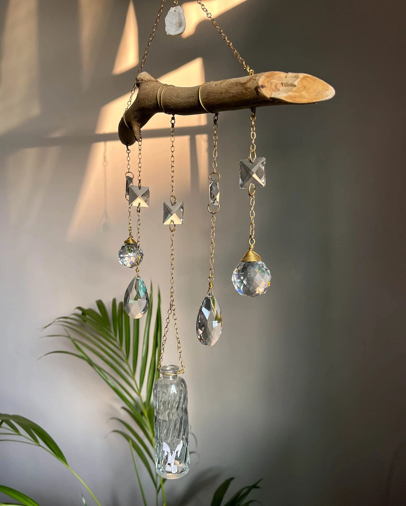 upcycled sun catcher with glass crystals, a wooden log base and a geode handmade by A Creator's Studio