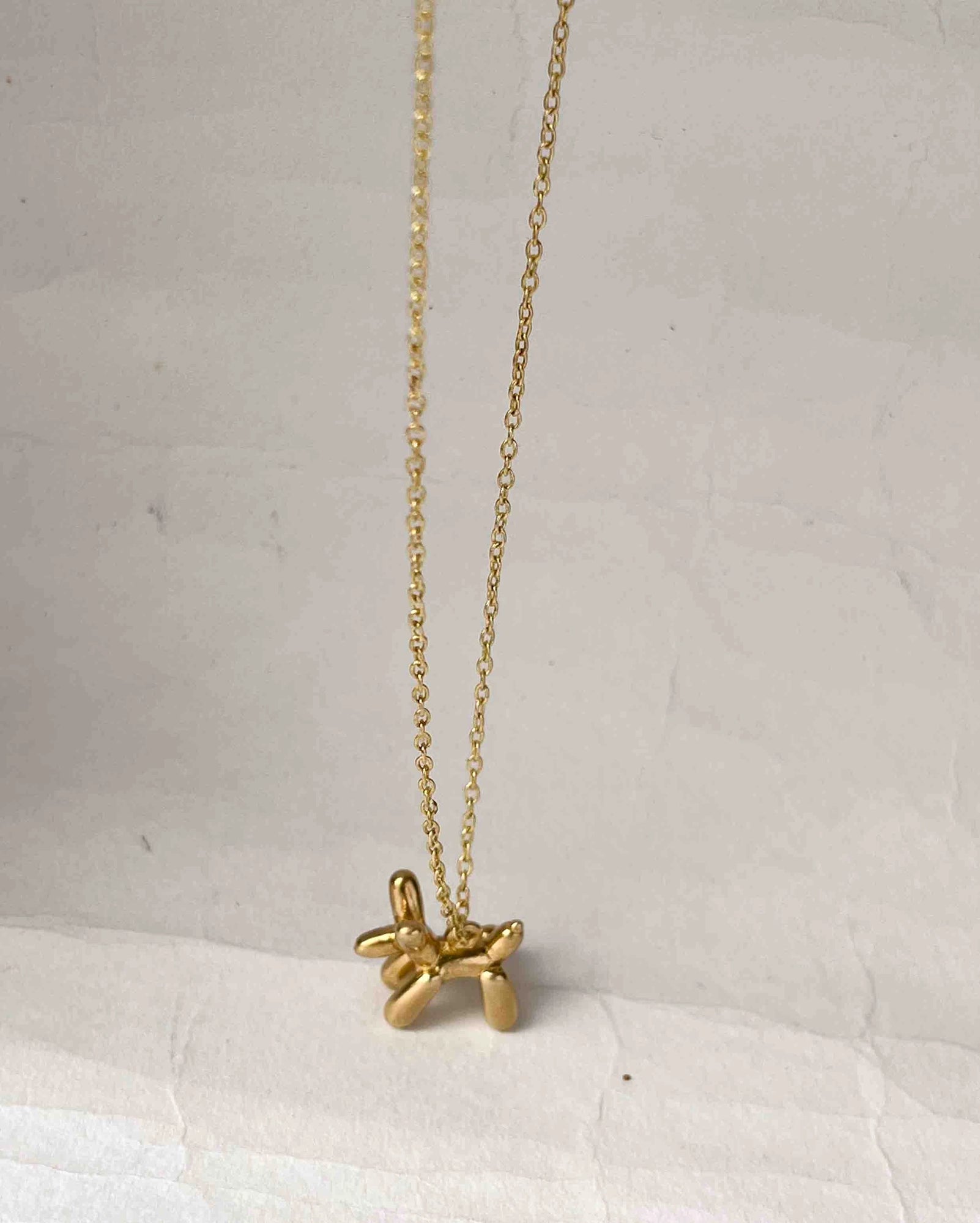 Brass necklace with a balloon dog pendant handmade by A Creator's Studio