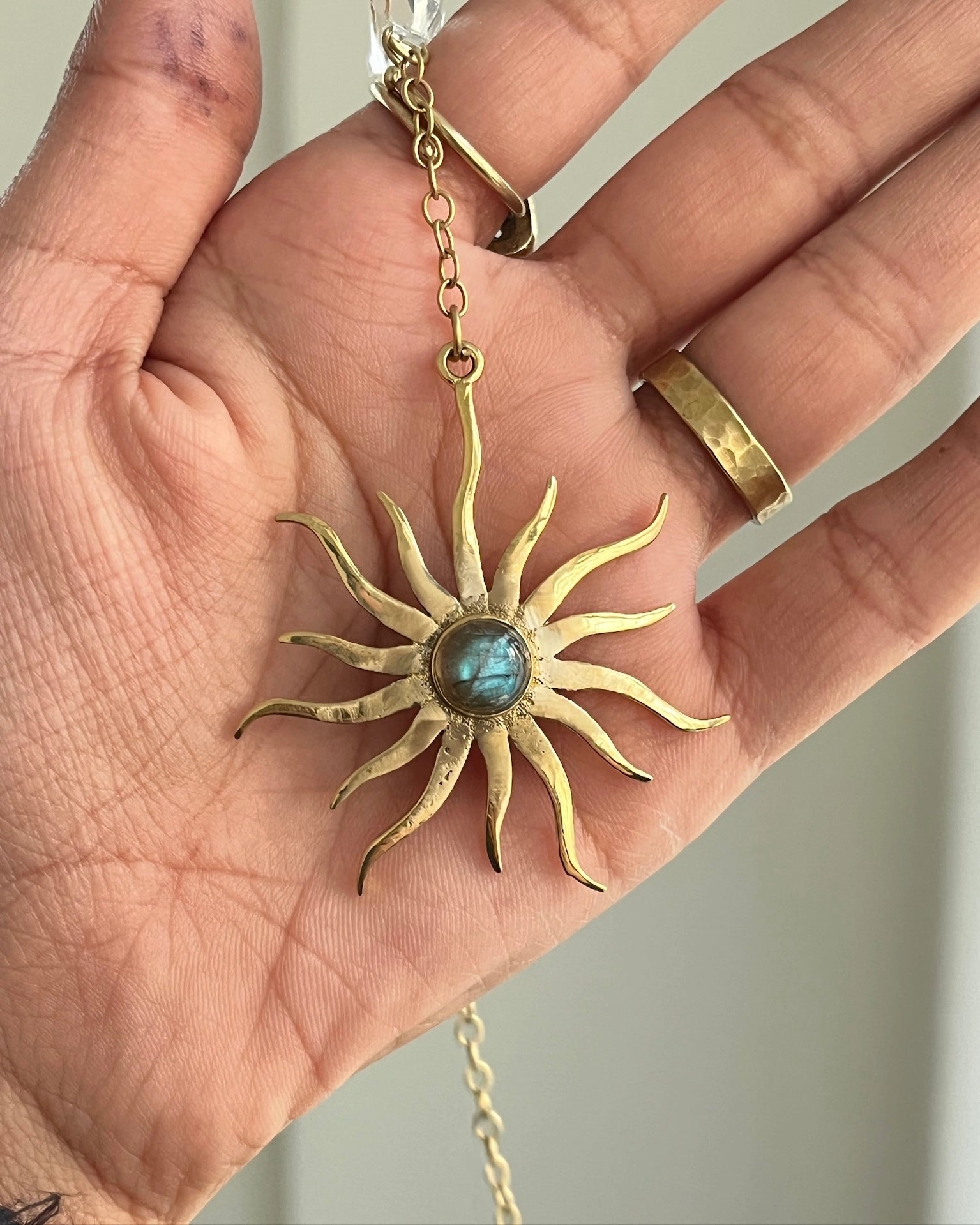 Brass sun-shaped car charm with a central gemstone handmade by A Creator's Studio