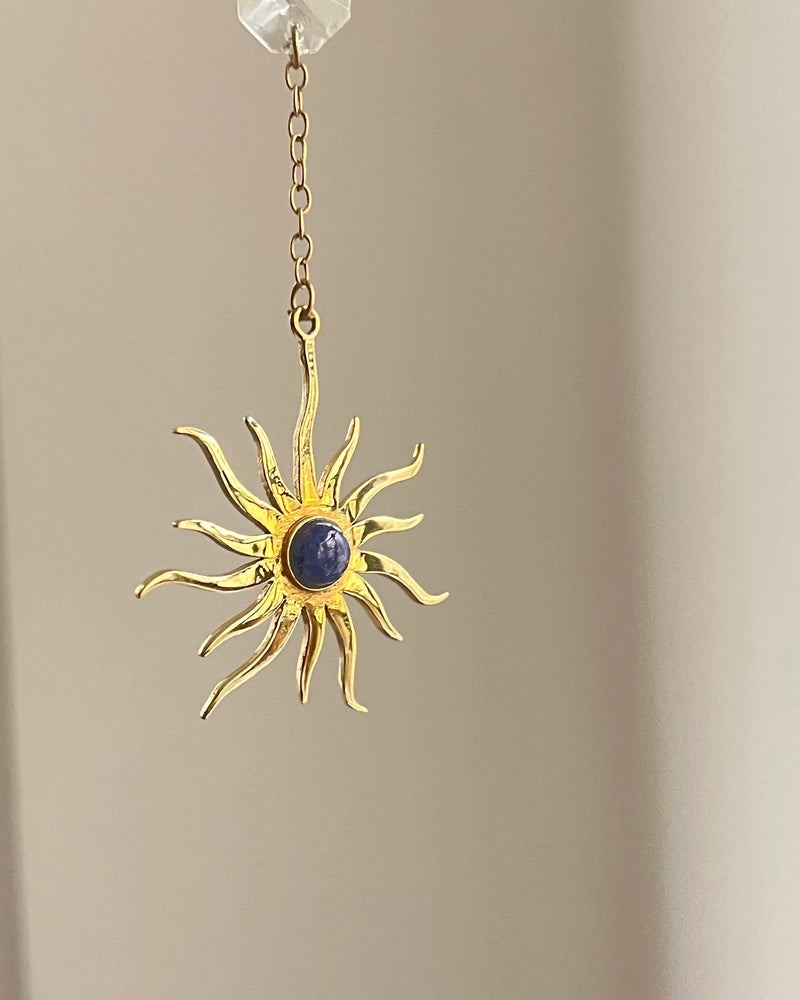 Brass sun-shaped car charm with a central gemstone handmade by A Creator's Studio