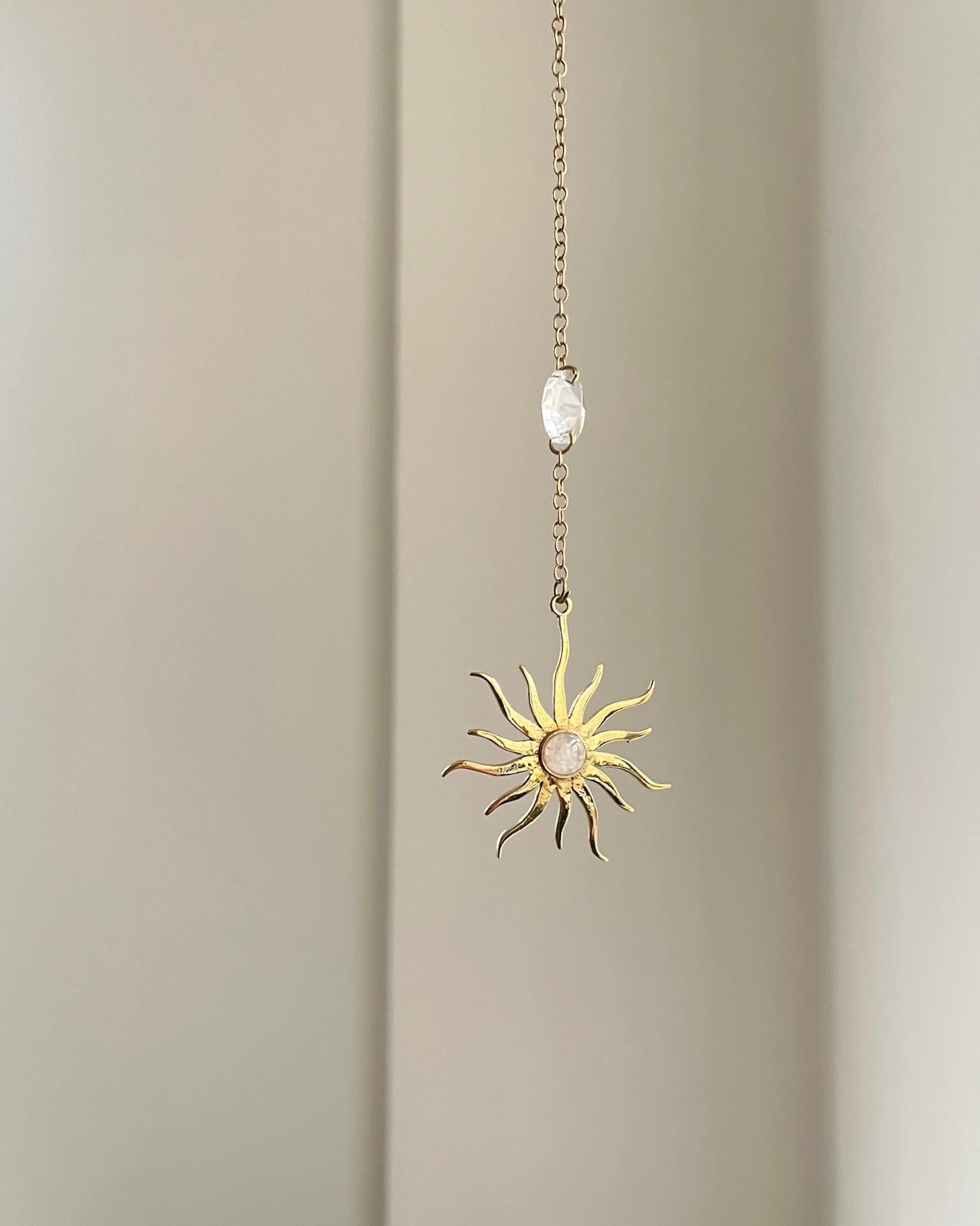 Brass sun-shaped car charm with a central gemstone handmade by A Creator's Studio