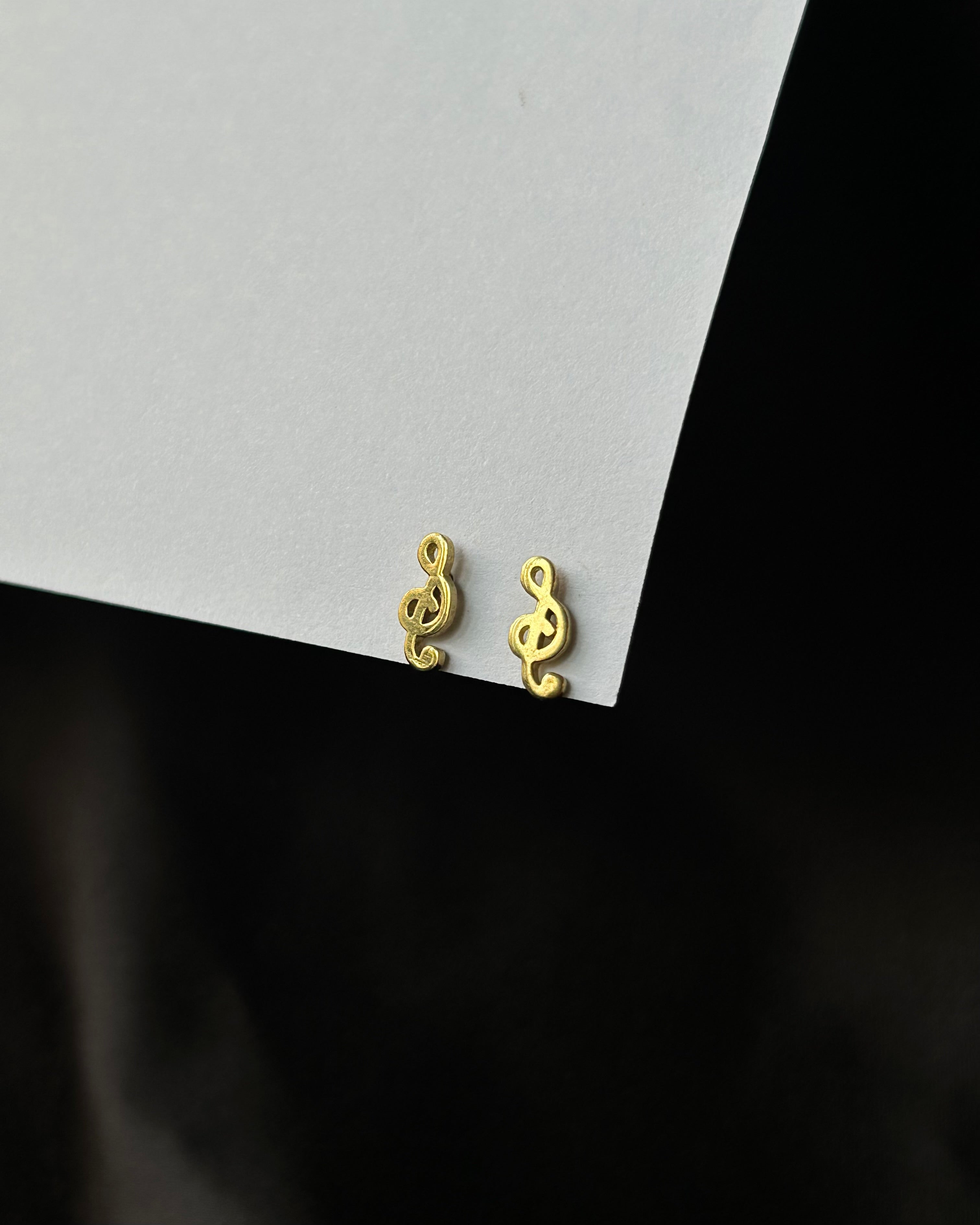 Brass musical note-shaped stud earrings handmade by A Creator's Studio