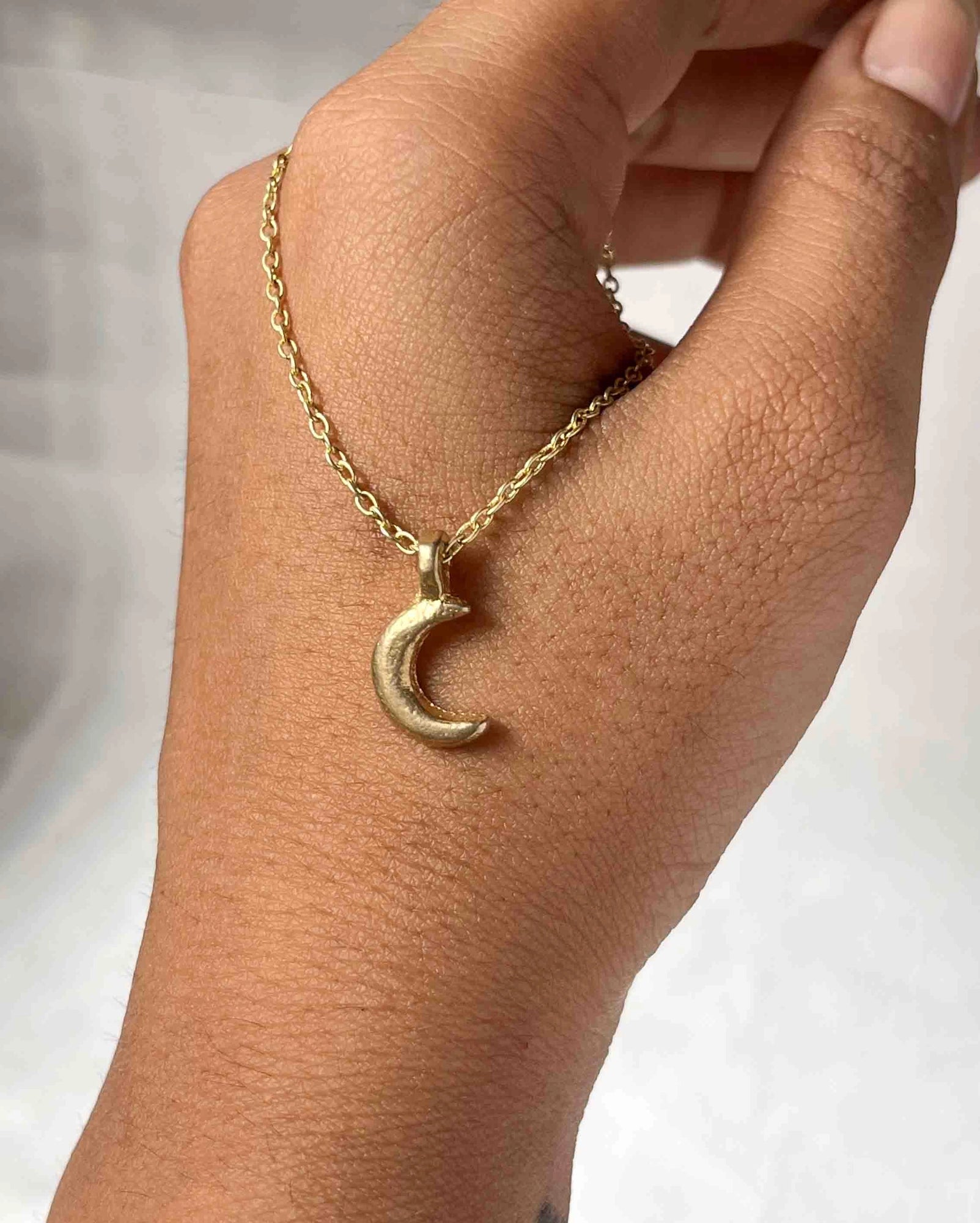 Brass necklace with a crescent moon pendant handmade by A Creator's Studio