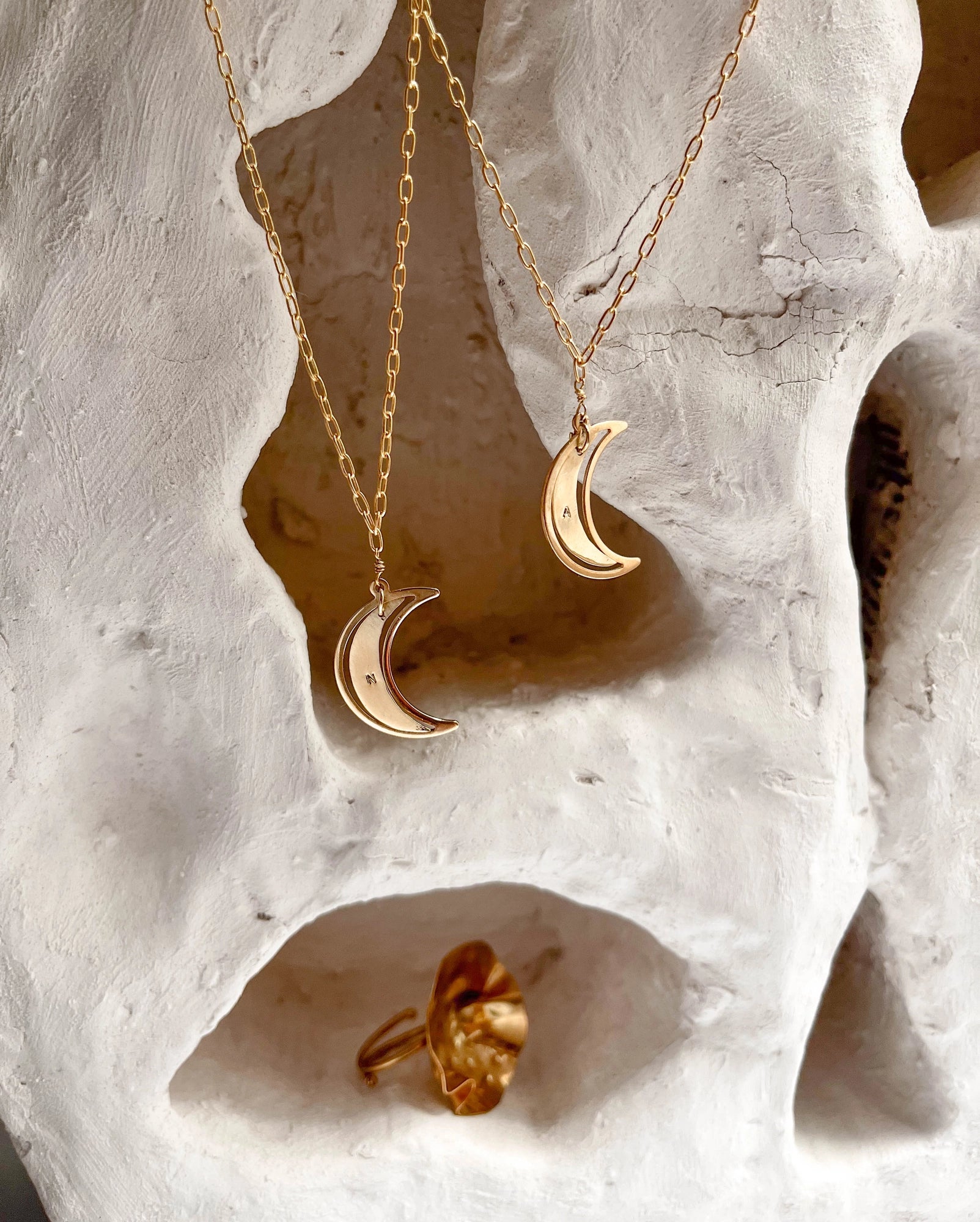 Brass necklace with a swinging and engraved crescent moon pendant handmade by A Creator's Studio