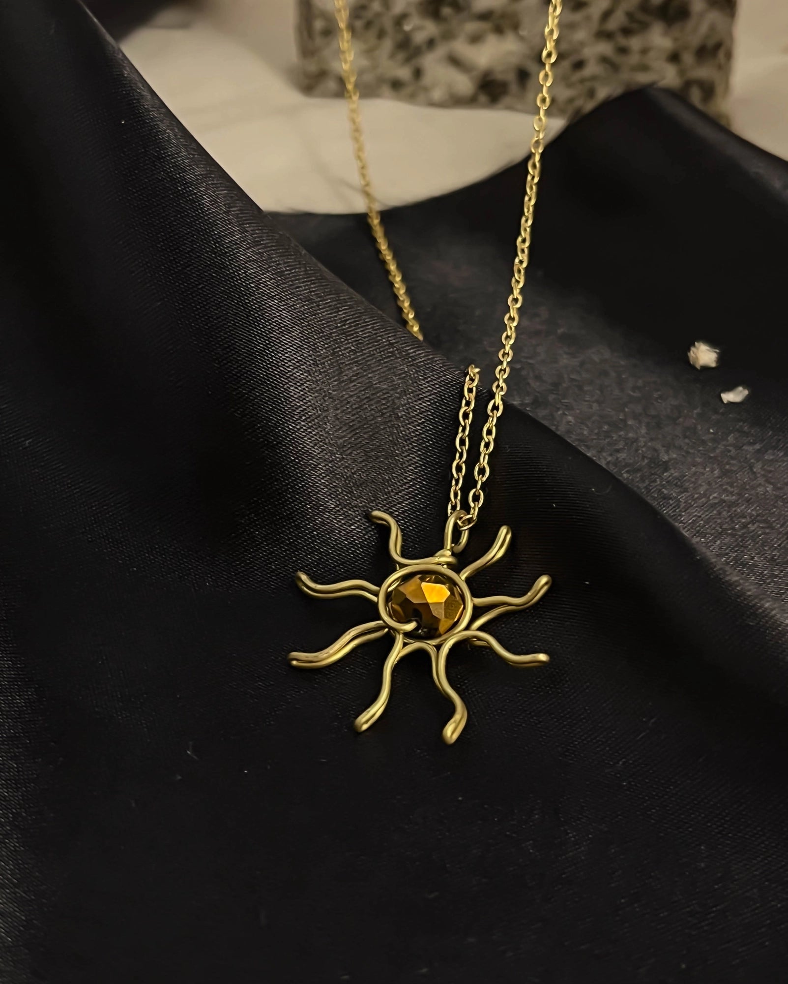Brass wired sun necklace with a crystal in the centre handmade by A Creator's Studio