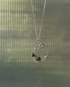 Sterling Silver Necklace with a wire wrapped moon pendant and an emerald gemstone handmade by A Creator's Studio