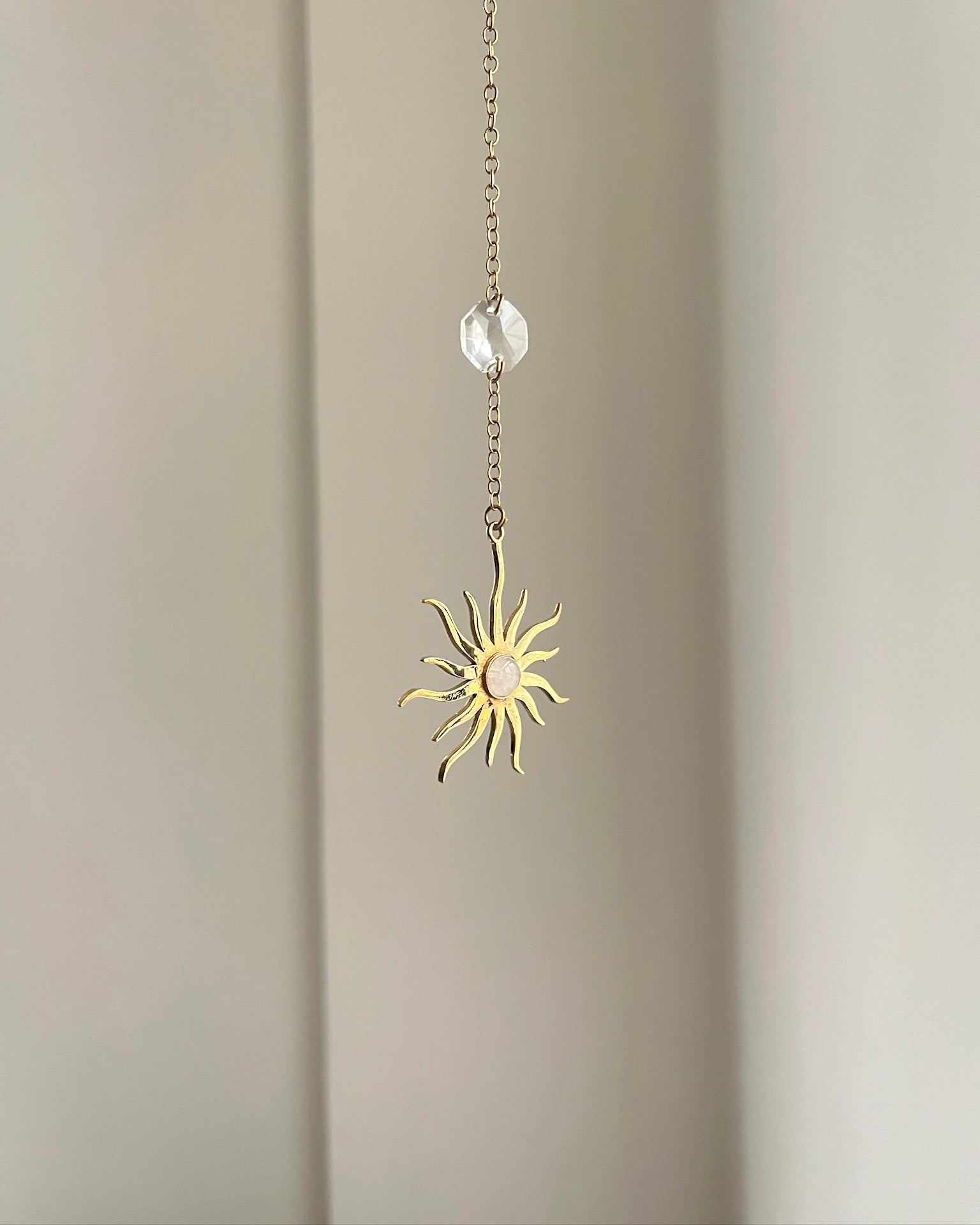 Brass sun-shaped car charm with a central gemstone handmade by A Creator's Studio
