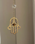 Brass hamsa-shaped car charm with a central gemstone handmade by A Creator's Studio