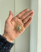 Brass sun-shaped car charm with a central gemstone handmade by A Creator's Studio