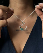 Sterling Silver Necklace with a wire wrapped moon pendant and an emerald gemstone handmade by A Creator's Studio